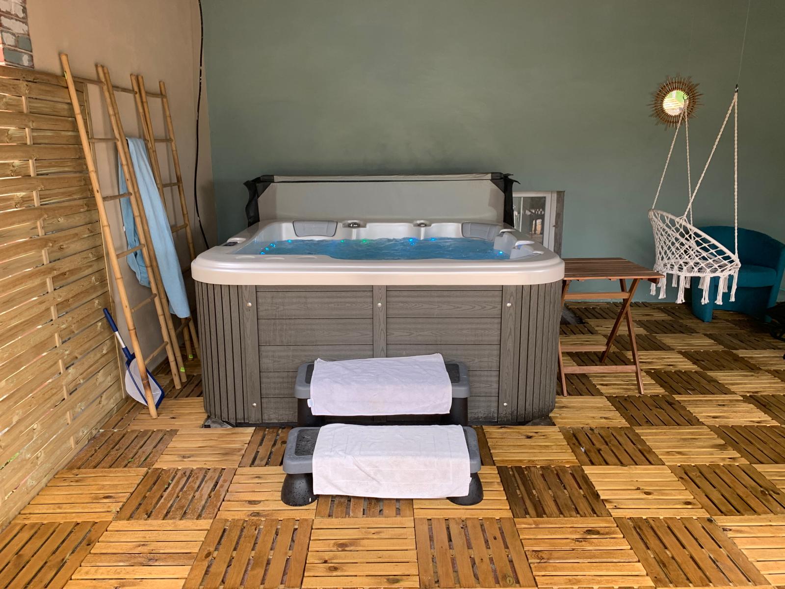 Le spa couvert et son coin détente, hamac et fauteuil suspendus