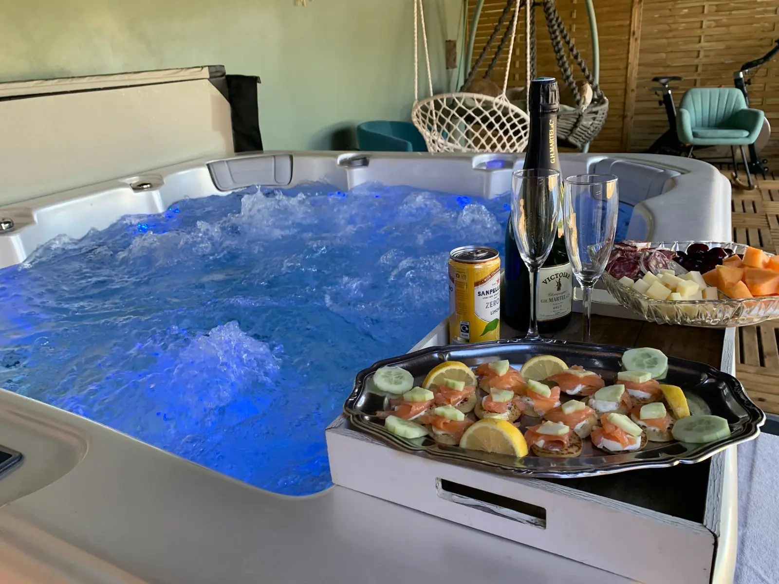 Le spa privatif couvert, en fonctionnement, avec plateau d'apéritif posé sur le rebord