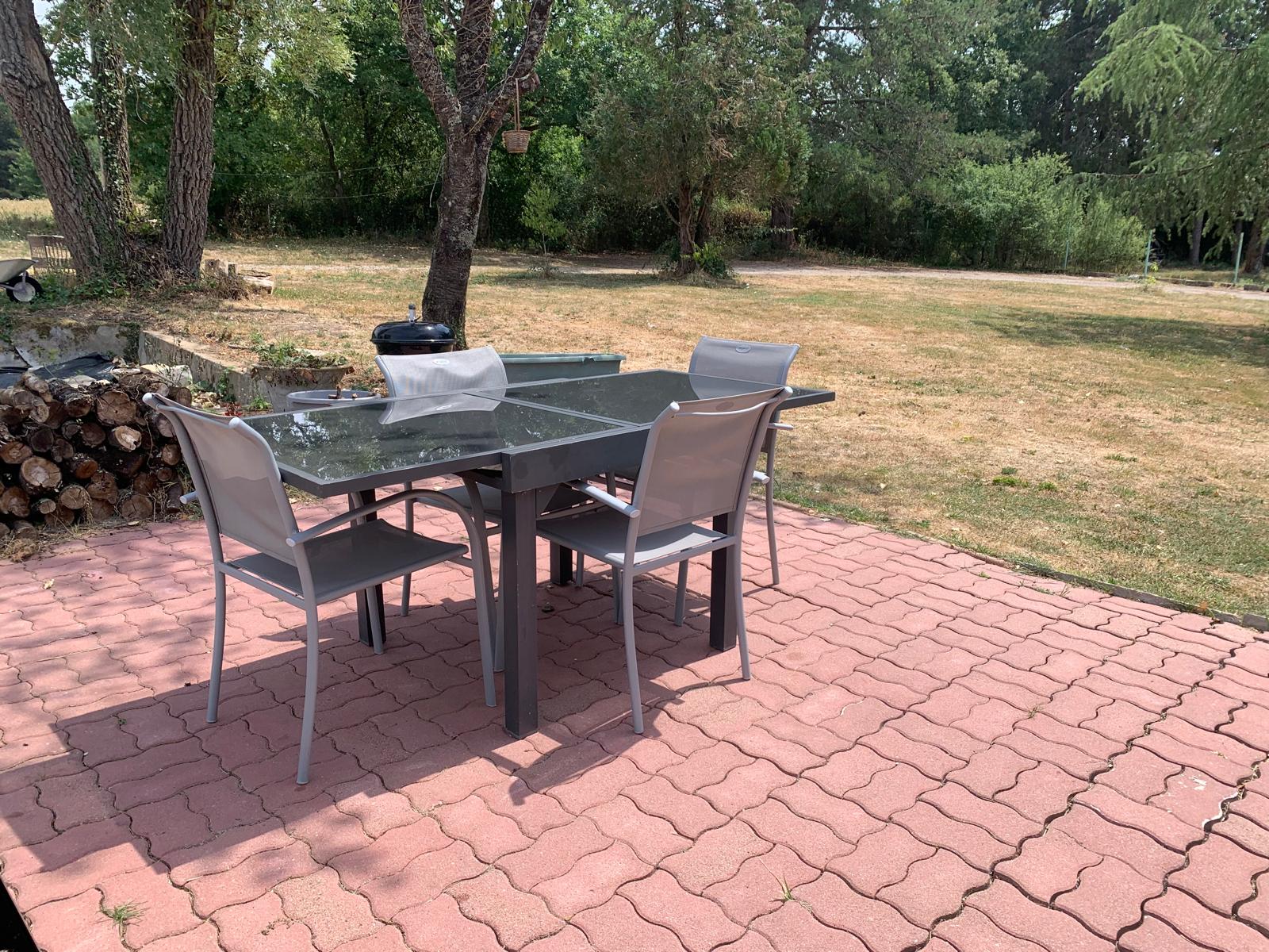 La terrasse d'été avec table de jardin et barbecue